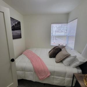 una camera da letto con un letto con cuscini e una finestra di Cozy Cottage near USU a Logan