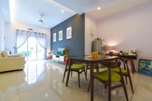 een keuken en een woonkamer met een tafel en stoelen bij Saffron Stay Melaka in Melaka