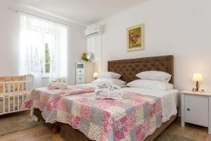 a bedroom with two beds and a crib at For All Seasons Apartment in Split