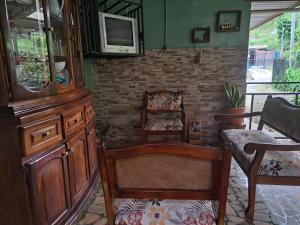 ein Wohnzimmer mit Stühlen und einem TV an der Wand in der Unterkunft Hospedaje Luis & Ana in Pejibaye
