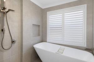 ダンズボローにあるNewly Built Luxury Modern Homeの窓のある浴室の白い浴槽 +15枚の写真