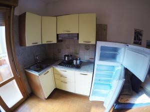 a small kitchen with yellow cabinets and a refrigerator at Condominio Cristina - Agenzia Cocal in Caorle