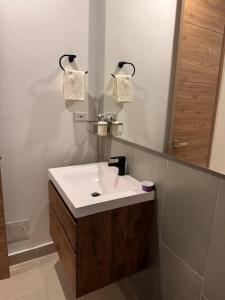 ein Badezimmer mit einem weißen Waschbecken und einem Spiegel in der Unterkunft Apartamento Celeste a Pasos del Mar y Aeropuerto in Santa Marta