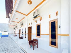 a corridor of a building with a bench on the floor at Elma Guesthouse YIA KulonProgo Yogyakarta Mitra RedDoorz in Yogyakarta