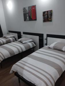 two beds in a room with white walls at jolie maison campagnarde in Gevrolles
