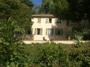 カンヌにある18th century villa in Cannes with poolの緑の艶戸と木々のある白い家