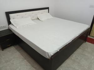 a large bed in a room with a white mattress at Hotel Harihar Atithi Bhawan in Naimishāranya