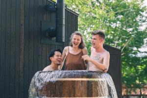two men and a woman standing in a fountain at Earthboat Togakushi in Nagano