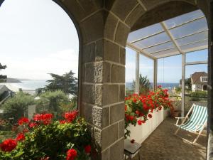 埃爾基的住宿－Beautiful holiday home with sea view in Erquy，一个带红色鲜花的海景庭院