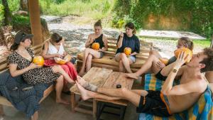 a group of people sitting on a bench eating pumpkins at Hostel Singha Lounge in Unawatuna