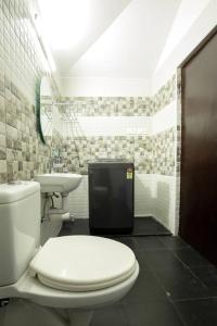 a bathroom with a toilet and a sink at Haven inn in Kotagiri