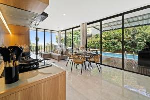 eine offene Küche und ein Wohnzimmer mit Poolblick in der Unterkunft Sukha by Kozystay - Dago in Bandung