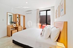 ein Schlafzimmer mit einem großen weißen Bett mit weißen Kissen in der Unterkunft Sukha by Kozystay - Dago in Bandung