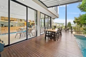 ein Esszimmer mit Glaswänden sowie einem Tisch und Stühlen in der Unterkunft Sukha by Kozystay - Dago in Bandung