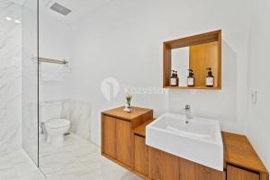 ein Badezimmer mit Waschbecken, Toilette und Spiegel in der Unterkunft Sukha by Kozystay - Dago in Bandung + 23 Fotos