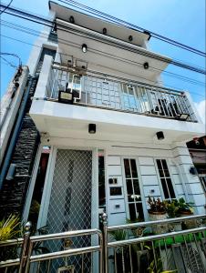 a white house with a balcony on top of it at Master's Bedroom The White Haven in Clark in Tacondo