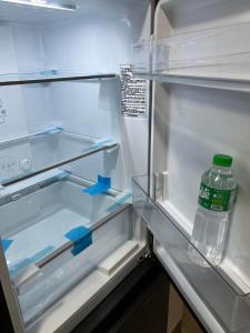 un refrigerador vacío con una botella de agua. en Okada complex 1BR with Balcony View, Sofa, Queen Bed and WIFI 8J, en Manila
