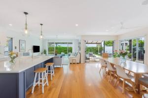 a kitchen and living room with a table and chairs at Casuarina Calm - Beach House with Pool by uHoliday in Casuarina