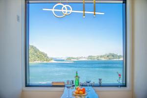 ein Fenster mit einem Tisch und Meerblick in der Unterkunft Geoje Dream Angel Pool Villa in Geoje