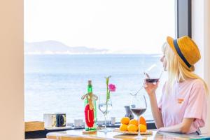 Eine Frau, die am Tisch sitzt und ein Glas Wein trinkt. in der Unterkunft Geoje Dream Angel Pool Villa in Geoje + 12 Fotos