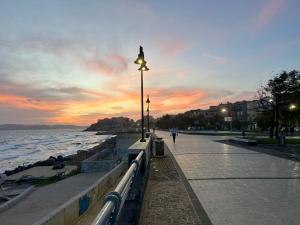 a street light next to the ocean at sunset at Casa Marisa Pozzuoli in Pozzuoli