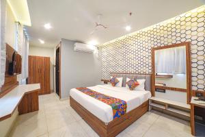 1 dormitorio con cama, lavabo y TV en FabHotel Bliss Residency, en Bhopal