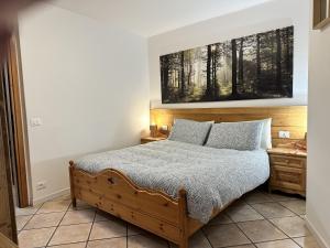 a bedroom with a bed and a painting on the wall at Il Mulino - Bilocale in centro in Ponte di Legno