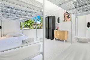 玛志洛Palms on Parker Backpackers的白色卧室配有床和木柜