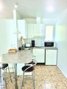 a kitchen with white cabinets and a table and chairs at Huvila saunalla ja paljulla Korpilammen rannalla in Espoo +22 photos