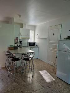 a kitchen with a table and chairs and a refrigerator at Huvila saunalla ja paljulla Korpilammen rannalla in Espoo