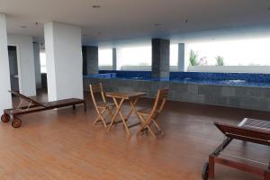 a room with a table and chairs and a pool at Comfort Stay Studio Room at Poris 88 Apartment By Travelio in Tangerang