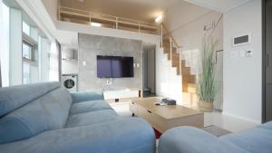 a living room with a blue couch and a tv at Blue Ocean Hotel 3 in Incheon