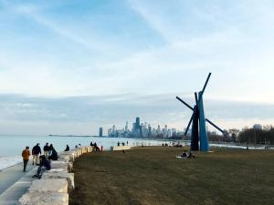 a group of people walking on the beach with a windmill at Entire Apartment in heart of Lincoln Park & Lake Sea and beach in Chicago +10 photos