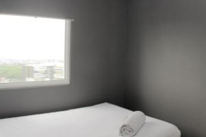 Gulta vai gultas numurā naktsmītnē Modern 2BR at Springlake Summarecon Bekasi Apartment By Travelio