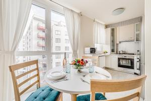 a kitchen and dining room with a white table and chairs at ARI - ARED Luxurious Apartments with Balcony & Free Parking in Arad