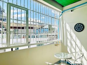 Un balcón con una silla y vista a un aeropuerto. en Charming Hostel, en Bangkok