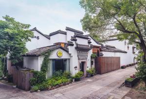 杭州Youxiake Canal Hotel Hangzhou的一栋前面有栅栏的白色房子