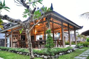 a wooden pavilion with a table in front of it at Kubudiuma Villas Bali in Canggu