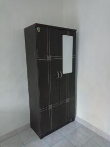 Tokomang Homestay في ليغِيان: خزانة سوداء مع باب في غرفة