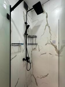 e bagno con doccia e parete in marmo. di ЖК Керуен Сарай 4 a Türkistan