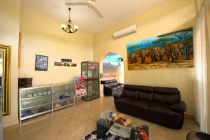 a living room with a couch and a painting on the wall at East Point Hotel Moshi in Moshi