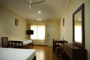 a bedroom with a bed and a desk and a mirror at Lakezone Holiday Resort in Chinnakanal
