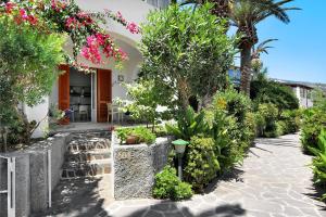 a garden area with a patio with flowers growing on it at Hotel Residence Mendolita in Lipari