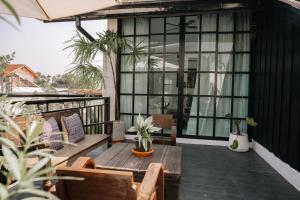 a patio with a wooden table and chairs on a balcony at The Courtyard Chiangrai in Chiang Rai