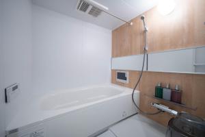 a bathroom with a bath tub and a shower at Zabo Hills 203 in Sapporo