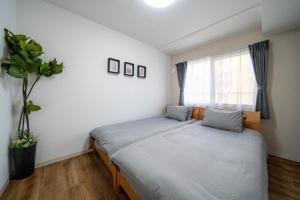 a bedroom with two beds and a window at Zabo Hills 203 in Sapporo