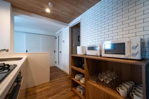 a kitchen with a counter and a microwave on a shelf at Zabo Hills 203 in Sapporo