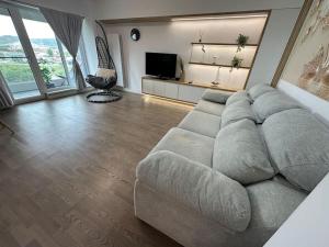 a living room with a large couch and a television at Escale a Iași-apartment in Iaşi