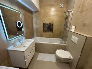 a bathroom with a tub and a toilet and a sink at Escale a Iași-apartment in Iaşi +21 photos