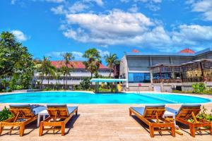 Una piscina con sillas y un edificio. en Kristal Hotel Kupang, en Kupang